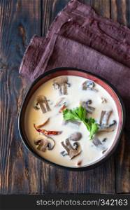 Bowls of thai tom kha soup on the wooden table