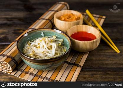 bowls sprouted beans red chili sauce with chopsticks placemat table