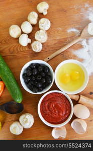 bowls with eggs, ketchup and olives on the kitchen table