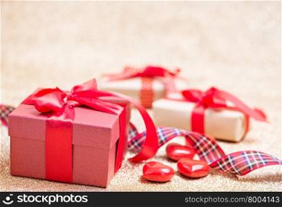 box for present and red hearts on a table