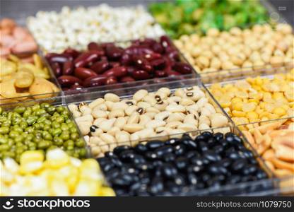 Box of different whole grains beans and legumes seeds lentils and nuts colorful snack background top view / Collage various beans mix peas agriculture of natural healthy food for cooking ingredients