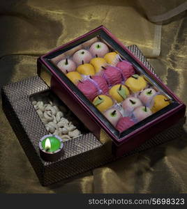 Box of sweets and nuts with a diya