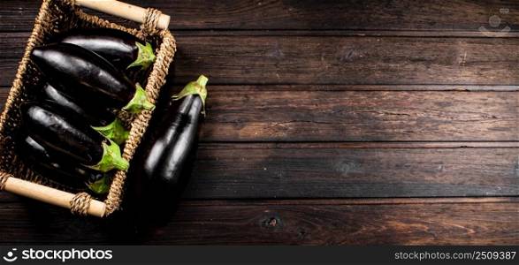 Box on a table with ripe eggplant. On a wooden background. High quality photo. Box on a table with ripe eggplant. 