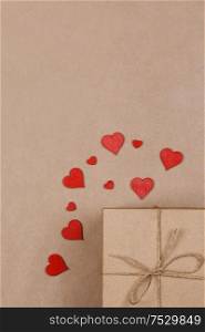 Box with gifts wrapped in brown craft paper and red paper hearts Valentines day concept. Gift and red hearts