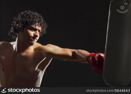 Boxer about to hit punching bag over black background