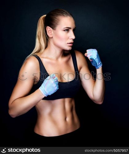 Boxer girl in action, isolated on black background, doing exercises in the studio, aggressive sport, healthy and active lifestyle