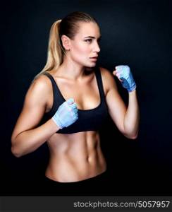 Boxer girl in action, isolated on black background, doing exercises in the studio, aggressive sport, healthy and active lifestyle