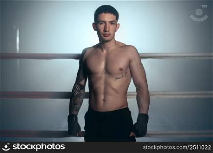Boxer, man posing in bandage on boxing ring. Fitness and boxing concept. High quality photo. Boxer, man posing in bandage on boxing ring. Fitness and boxing concept.
