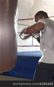 Boxer using punching bag in gym