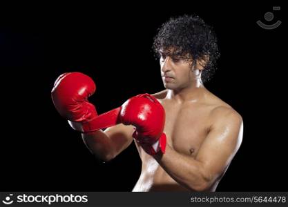 Boxer wearing gloves over black background