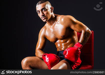 Boxer with red gloves in dark room