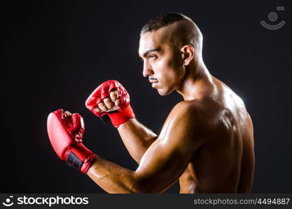 Boxer with red gloves in dark room