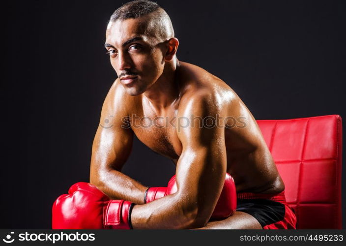 Boxer with red gloves in dark room