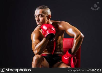Boxer with red gloves in dark room