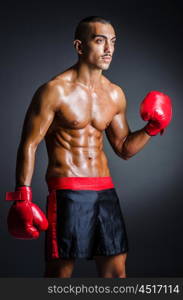 Boxer with red gloves in dark room