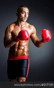 Boxer with red gloves in dark room