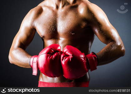 Boxer with red gloves in dark room