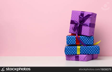 boxes packed in festive blue paper and tied with silk ribbon on white background, birthday gift, surprise, copy space