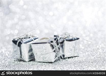 Boxes with christmas gifts on shiny silver background