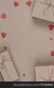 Boxes with gifts wrapped in brown craft paper and red paper hearts Valentines day concept. Gifts and red hearts