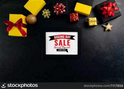 Boxing day sale with Christmas present and xmas decoration on black background