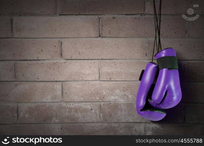 Boxing gloves hanging on nail on wall. Boxing gloves