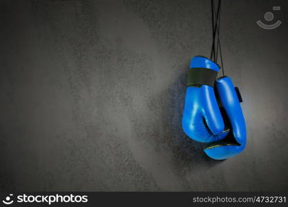 Boxing gloves hanging on nail on wall. Boxing gloves