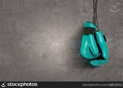 Boxing gloves hanging on nail on wall. Boxing gloves