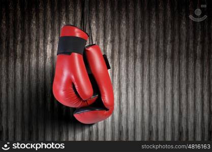 Boxing gloves. Pair of red boxing gloves hanging on wall