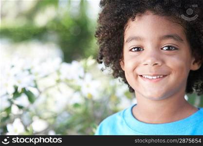 Boy (5-6 years) smiling outdoors portrait close-up