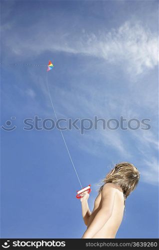 Boy (7-9) flying kite, low angle view