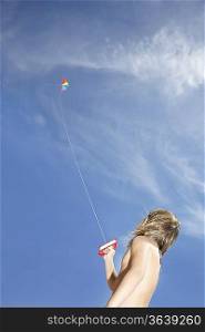 Boy (7-9) flying kite, low angle view