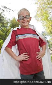 Boy (7-9) wearing cape and swimming goggles