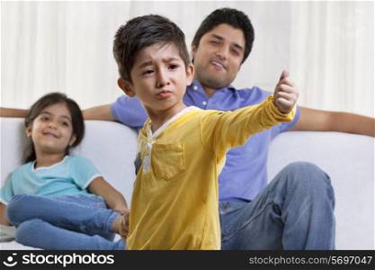Boy acting in front of father and sister