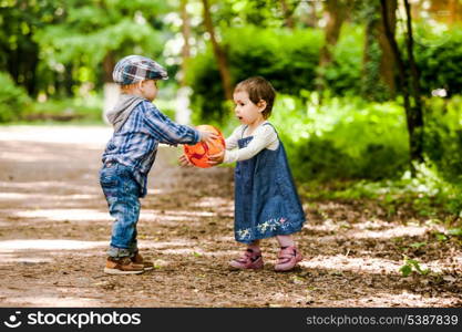 Boy and girl are playing with ball outdoor