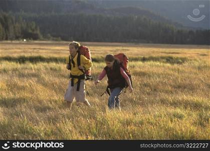 Boy and Girl Hiking Across the Plain