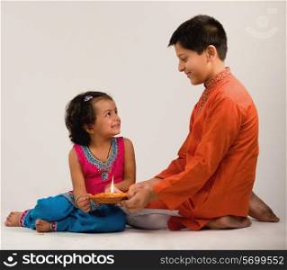 Boy and girl holding a diya together