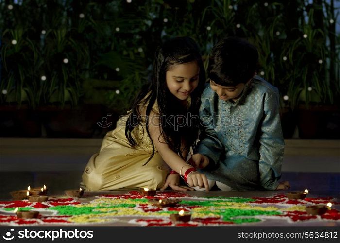 Boy and girl making a rangoli