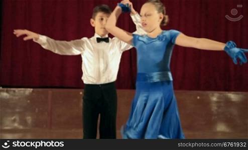 boy and girl of 9 years dancing the jive in the ballroom. DOF