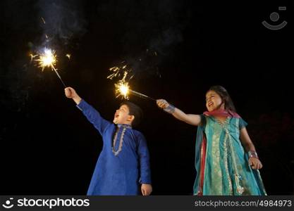 Boy and girl playing with sparklers