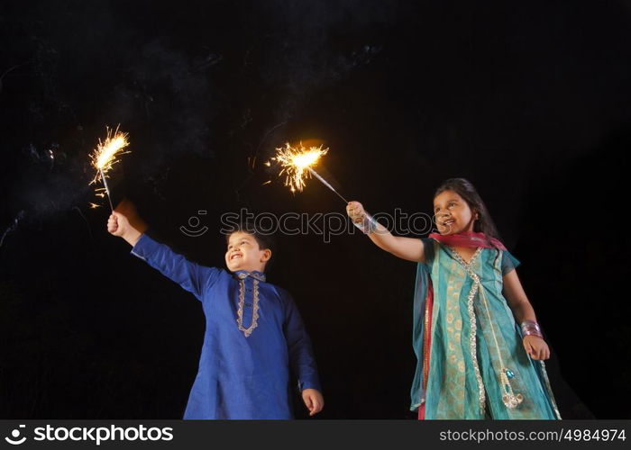 Boy and girl playing with sparklers