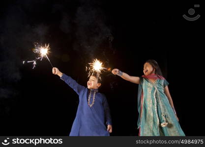 Boy and girl playing with sparklers