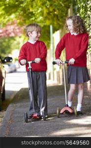Boy And Girl Riding Scooter On Their Way To School