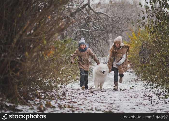 Boy and girl running a race with the Samoyed.. Children run the race with his beloved dog 9848.