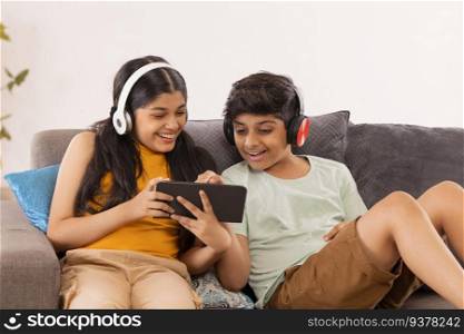 Boy and girl using digital tablet and listening music on headphones