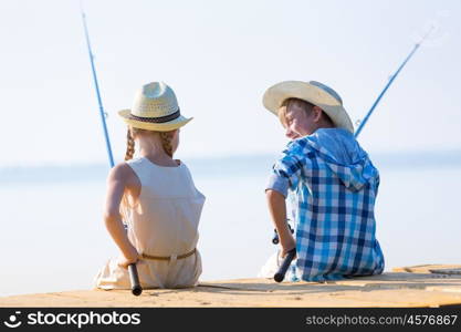 Boy and girl with fishing rods. Boy and girl with fishing rods fishing together from a pier