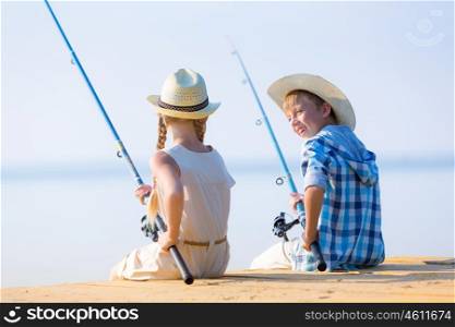 Boy and girl with fishing rods. Boy and girl with fishing rods fishing together from a pier