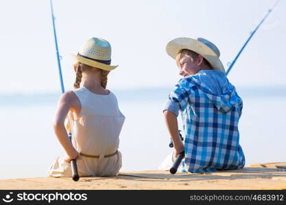 Boy and girl with fishing rods. Boy and girl with fishing rods fishing together from a pier