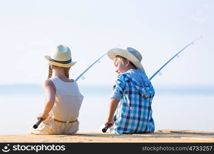 Boy and girl with fishing rods. Boy and girl with fishing rods fishing together from a pier