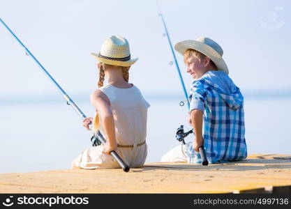 Boy and girl with fishing rods. Boy and girl with fishing rods fishing together from a pier